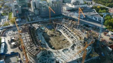 Turnalı spor arenası manzarası. Stok görüntüleri. Yazın modern şehrin merkezinde spor arenası inşa ediliyor. Şehirdeki spor sahasında bir sürü vinç var.