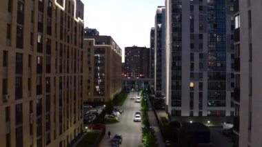 Modern konut binaları olan cadde manzarası. Stok görüntüleri. Şehrin modern yerleşim bölgesinin güzel sokak manzarası. Modern bölgenin parıldayan evleri ve caddeleri. 