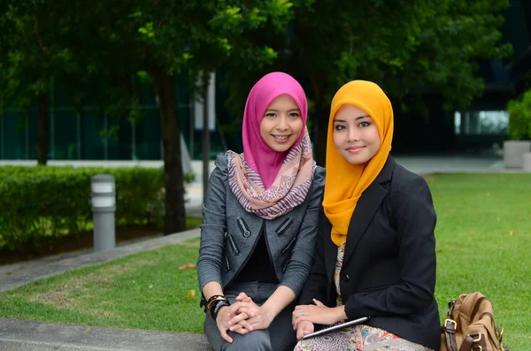Junge asiatische muslimische Geschäftsfrauen mit Kopftuch lächeln mit ihrem mobilen Laptop — Stockfoto