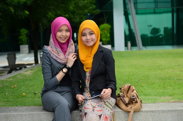 Junge asiatische muslimische Geschäftsfrauen mit Kopftuch lächeln mit ihrem mobilen Laptop — Stockfoto