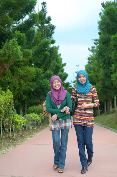 Молодая азиатская мусульманка в головном шарфе улыбается в парке — стоковое фото