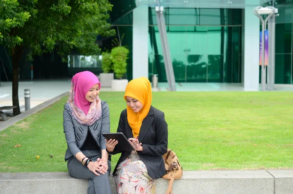 Młodych azjatyckich przedsiębiorców muzułmańskich w głowie szalik uśmiech z mobile laptop — Zdjęcie stockowe