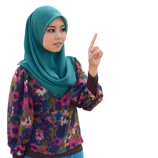 Молодая азиатская мусульманка в шарфе на голове улыбается указательным пальцем — стоковое фото