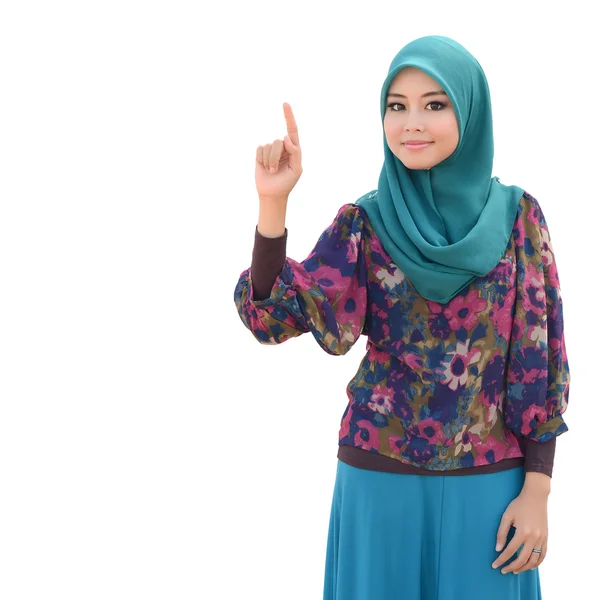 Молодая азиатская мусульманка в шарфе на голове улыбается указательным пальцем — стоковое фото