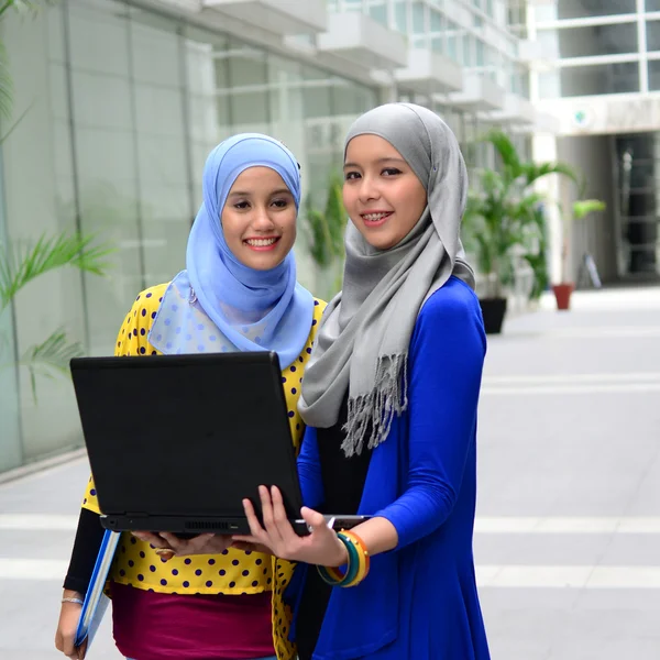 Two young pretty Asian muslim business woman in head scarf — Stock Photo, Image