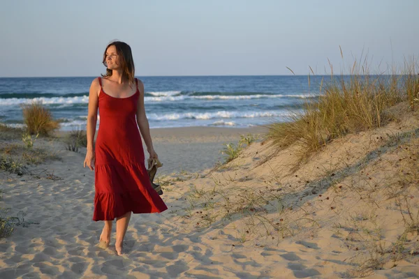 Schöne junge Frau, die vom Strand zurückgeht — Stockfoto