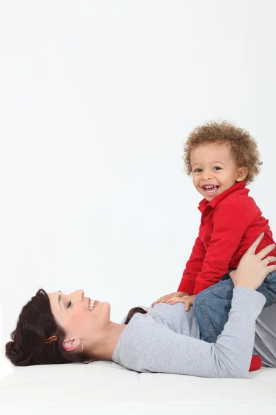 Mother resting son on belly — Stock Photo, Image