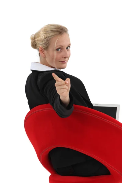 Mulher sentada na cadeira apontando — Fotografia de Stock