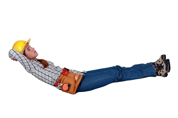 Female builder laying in invisible hammock — Stock Photo, Image