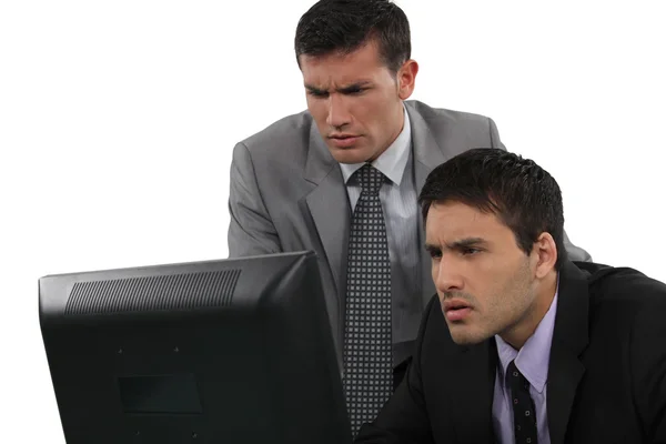 Zwei seriöse Geschäftsleute konzentrieren sich auf Laptop-Bildschirm — Stockfoto