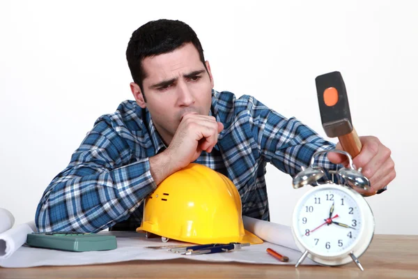Tired tradesman about to smash his alarm clock — Stock Photo, Image