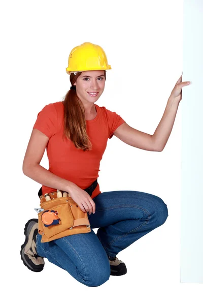 Tradeswoman holding up a sign — Stock Photo, Image