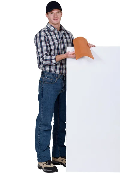 屋根葺き職人タイルと空白のポスターに立っていた — ストック写真