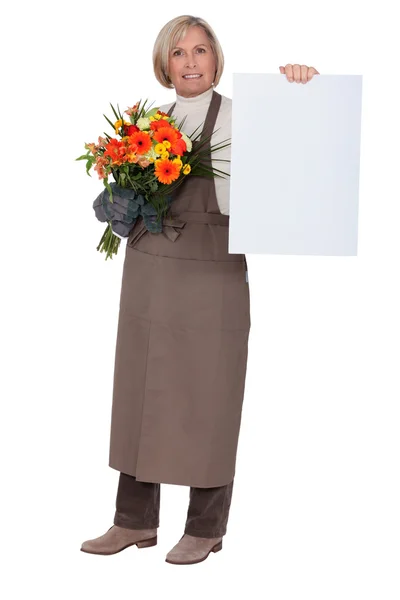 Florist with a bouquet and a board left blank for your message — Stock Photo, Image