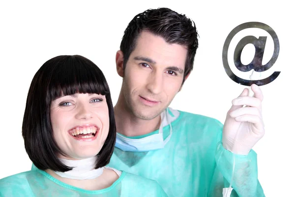 Doctors holding up the at symbol — Stock Photo, Image