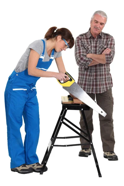 Vrouwelijke leerling hout zagen — Stockfoto