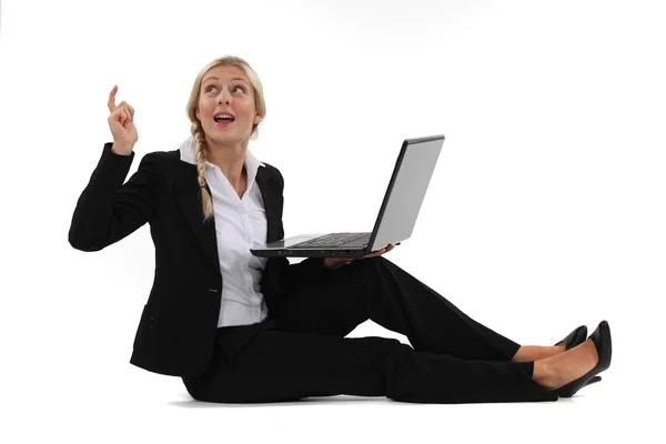 Frau sitzt mit ihrem Laptop auf dem Boden und hat eine großartige Idee — Stockfoto