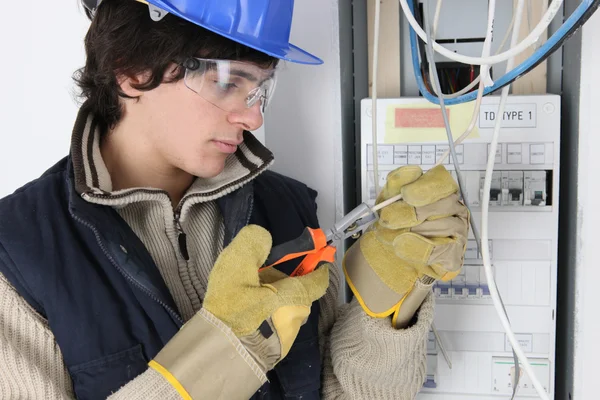 Jeune électricien travaillant sur une boîte à fusibles — Photo