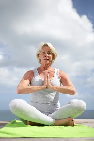 Mujer mayor en una posición de yoga —  Fotos de Stock