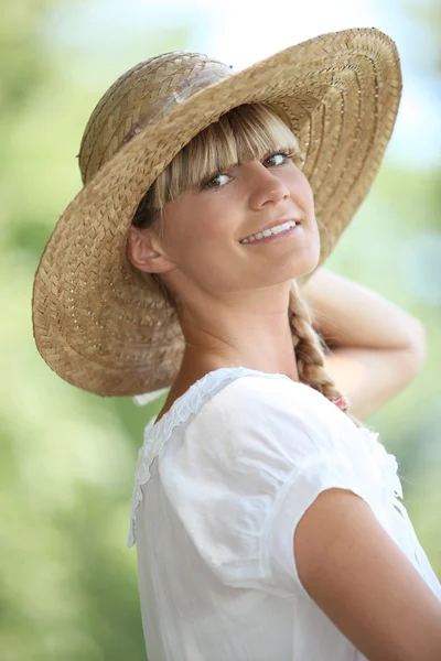 Портрет блондинки на улице в соломенной шляпе — стоковое фото