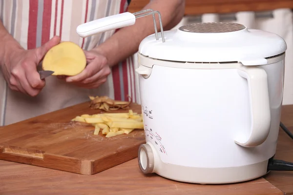 Man skalar potatis att göra pommes frites — Stockfoto