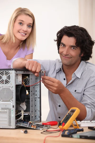 Kvinnan tittar på sin man reparera en dator — Stockfoto