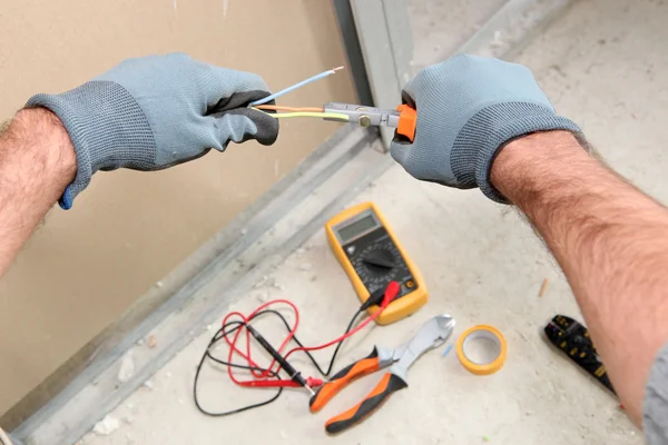 Elektriker tar en behandling med en voltmeter — Stockfoto
