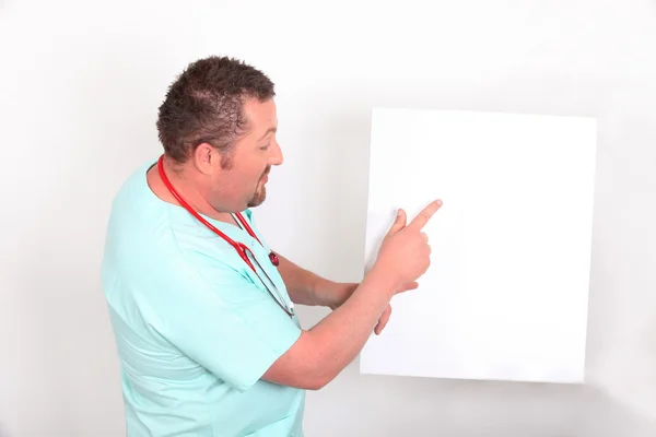 Arzt zeigt auf ein leeres Schild — Stockfoto