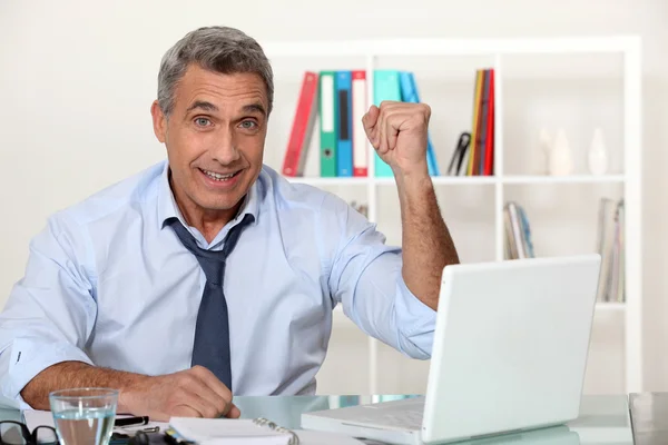 Возбужденный бизнесмен с ноутбуком — стоковое фото