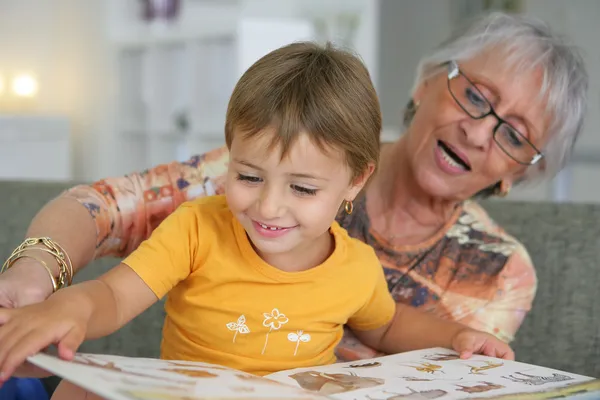 Abuela leyendo con un niño pequeño — Foto de Stock