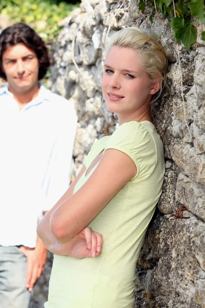 Casal no campo na frente da parede — Fotografia de Stock