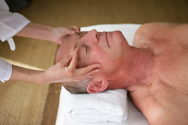 Äldre man med en massage på ett spa-center — Stockfoto