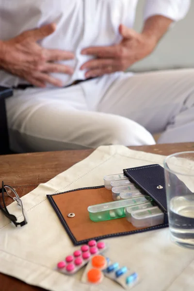 Hombre con dolor de estómago y pastillas — Foto de Stock