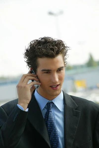 Молодой бизнесмен разговаривает по мобильному — стоковое фото