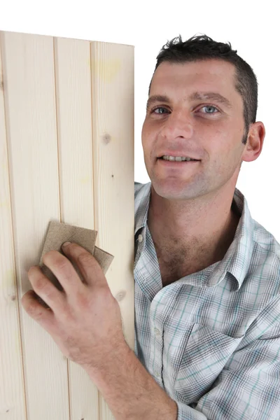 Carpenter sanding plank of wood — Stock Photo, Image