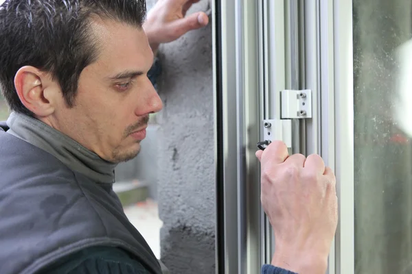 Hombre encajando una ventana — Foto de Stock