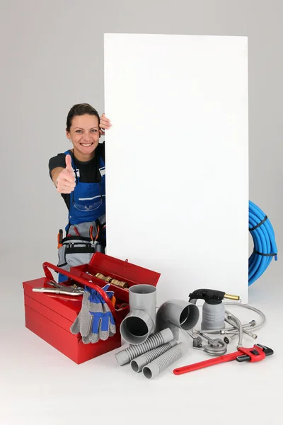 Trabalhadora feminina alegre com painel e caixa de ferramentas — Fotografia de Stock