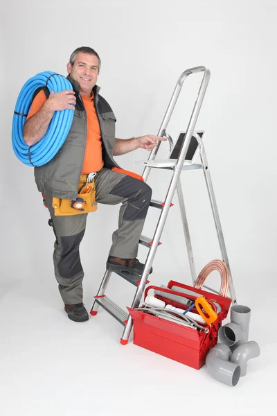 Man met ladder en sanitair gereedschap — Stockfoto