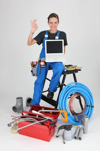 Mujer fontanero mostrando portátil haciendo OK signo —  Fotos de Stock