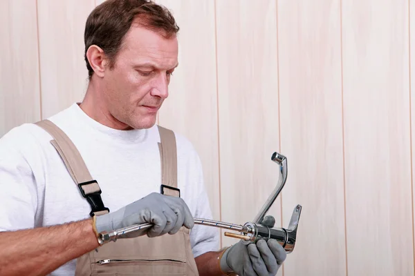 Handy homem segurando torneira — Fotografia de Stock