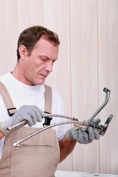 Handwerker montiert einen Wasserhahn in der Küche — Stockfoto