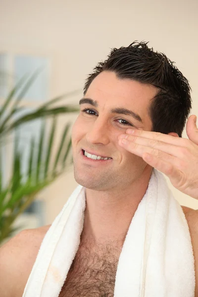 Man toepassing moisturizer — Stockfoto