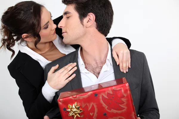 Couple with Christmas present about to kiss — Stock Photo, Image