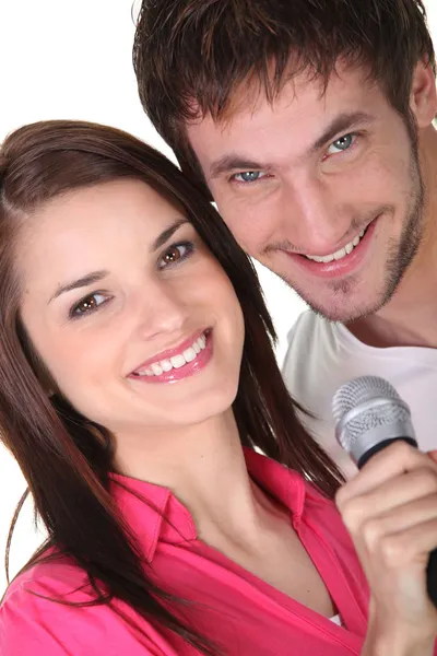 Pareja cantando en un micrófono — Foto de Stock