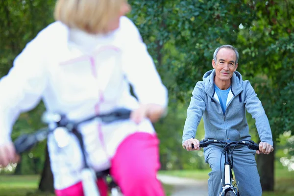 Pareja de mediana edad en un paseo en bicicleta — Foto de Stock