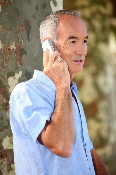 Senior citizen making a call outdoors — Stock Photo, Image