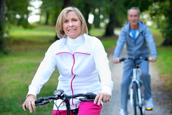 Äldre par njuter av en cykeltur — Stockfoto