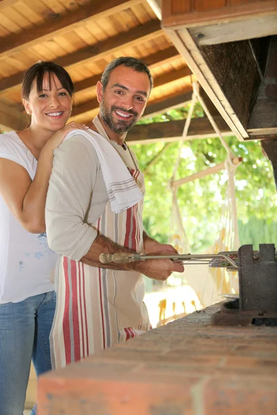 Pareja teniendo una barbacoa al aire libre — Foto de Stock