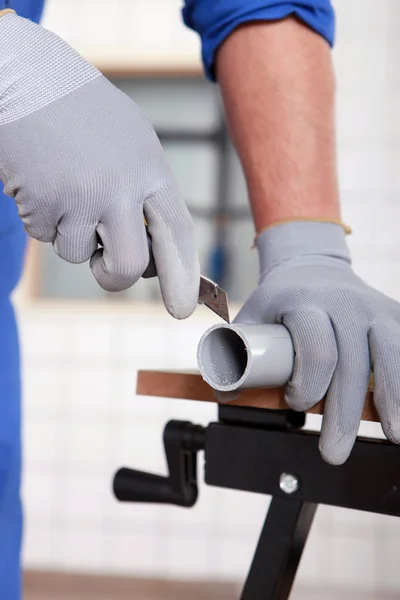 Plumber cutting plastic pipe to size — Stock Photo, Image