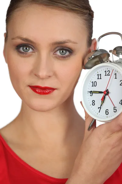 Blond woman displaying alarm clock Stock Picture